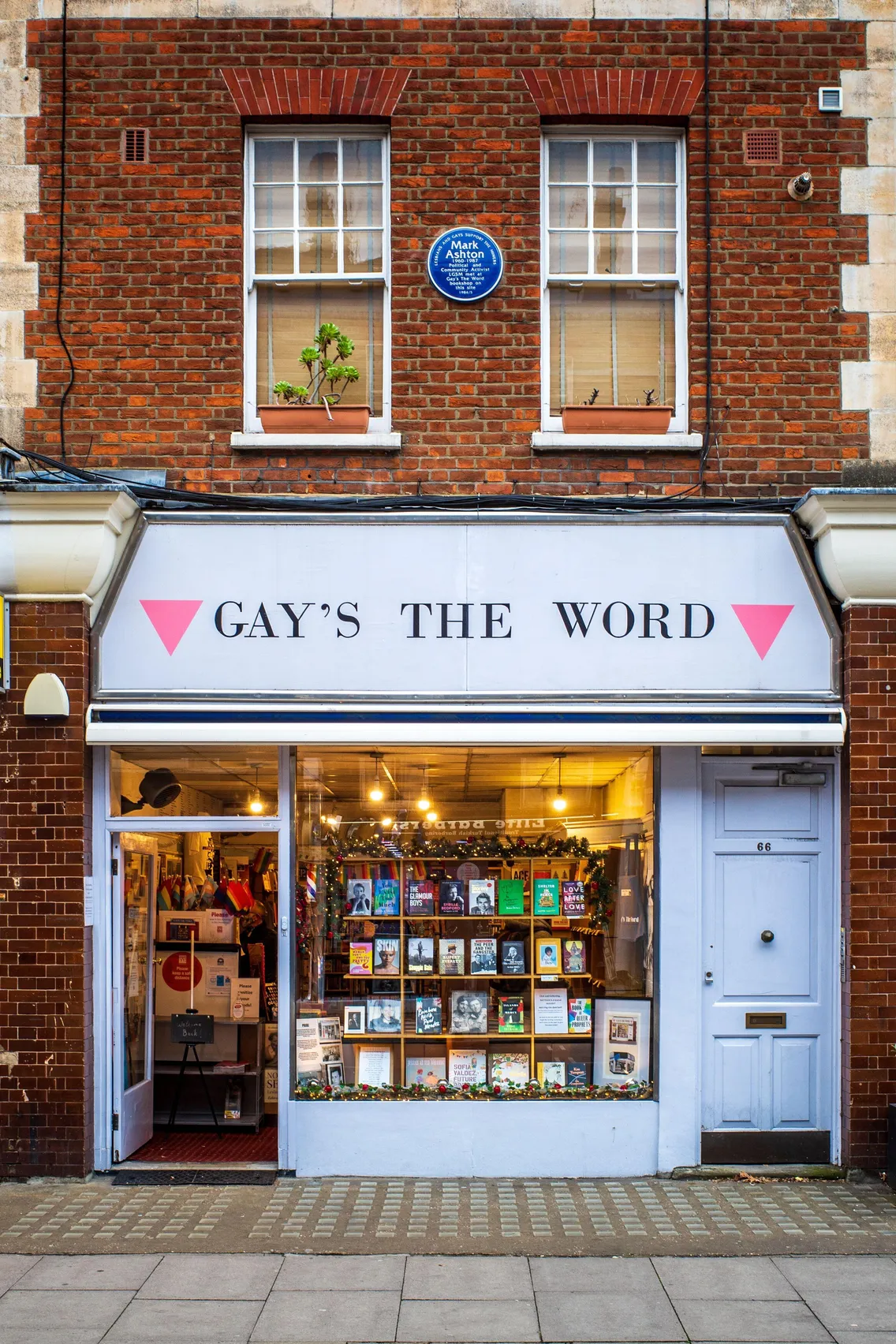 A bookshop facade with 'Gay's The Word' above the entrance and two pink triangles pointing downwards